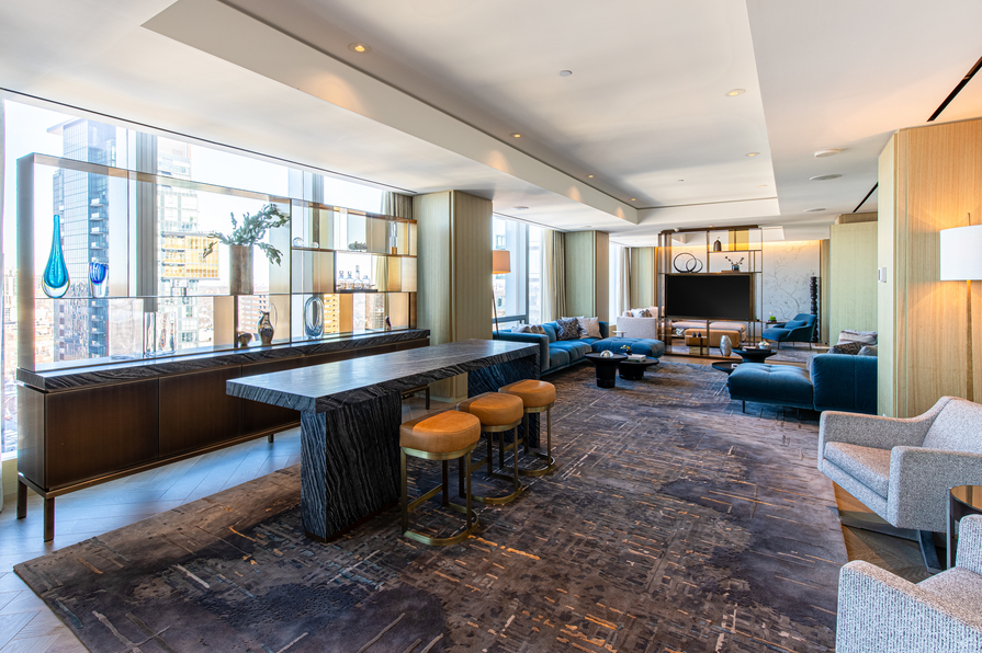 Room with a bar and couches in a hotel suite.