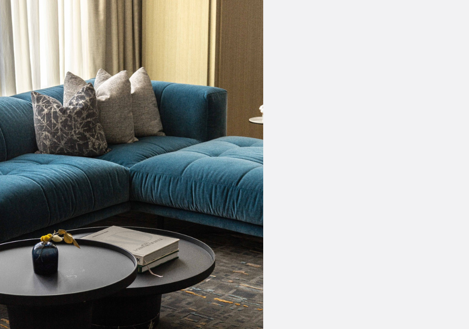 Blue couch and a round, black coffee table.
