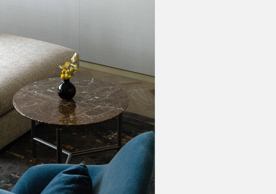 Round, dark granite table with flower vase placed in the centre.